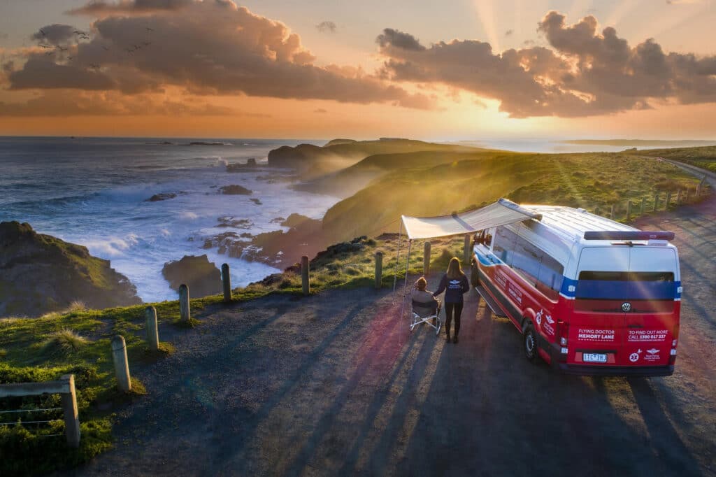 A Flying Doctor Memory Lane campervan parked on the coast at sunset.