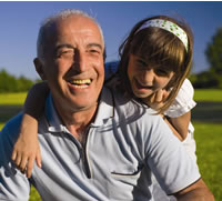 Older man smiling with grand-daughter on his shoulders. Photo: DMS