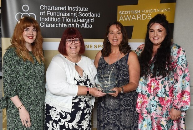 The SiMBA team with Michelle Chambers from Think, receiving their Fundraising Team of the Year Award