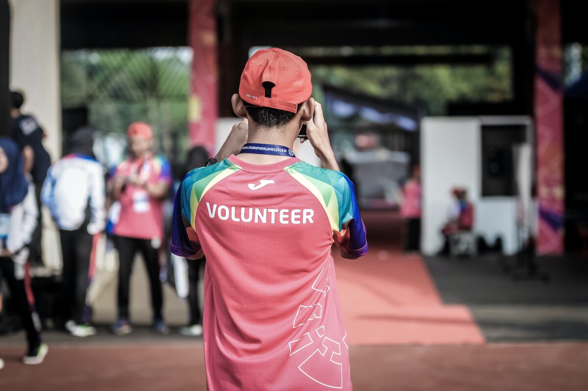 The back of a young person in a top that says volunteer