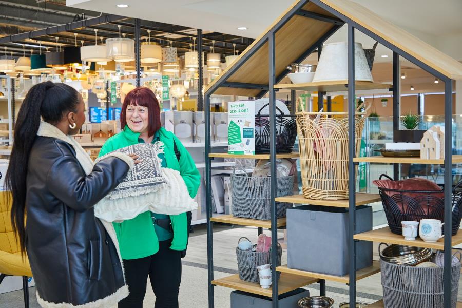 A Dunelm employee talks to a woman dropping off some donations for its Home to Home initiative