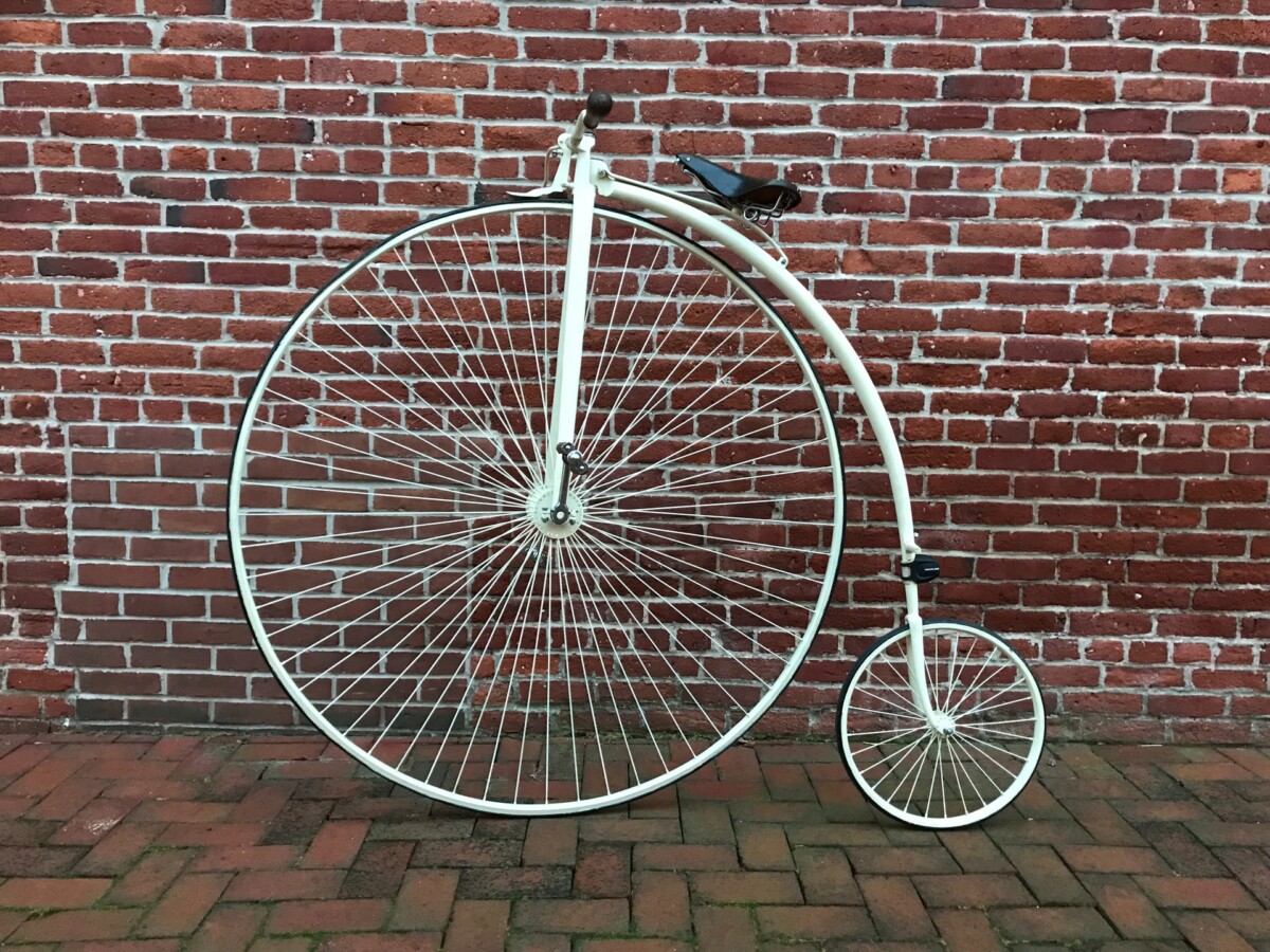 Penny farthing bicycle against a brick wall
