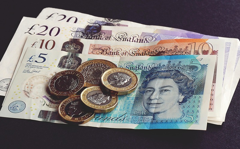 A pile of english bank notes and coins by Suzy Hazelwood on Pexels